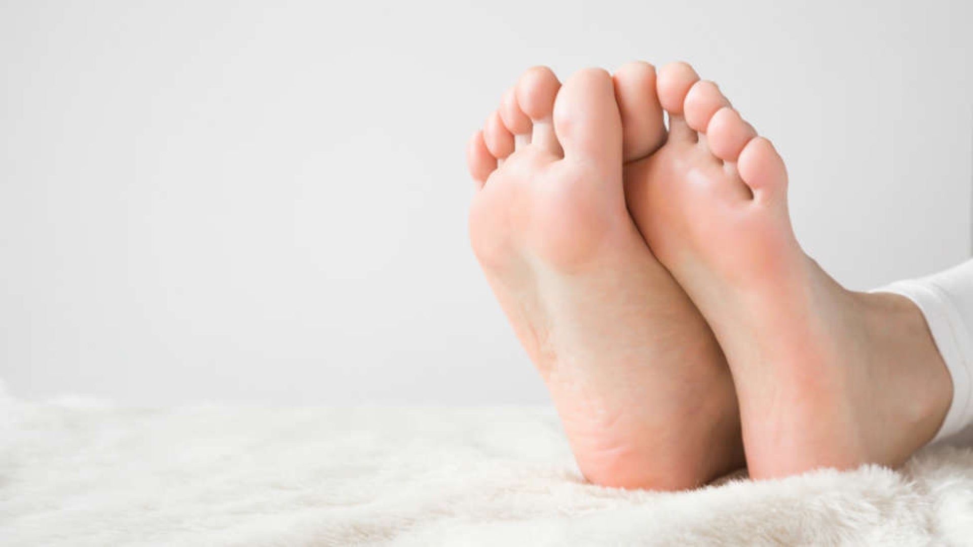 Person trying EMS foot stimulation at home for the first time