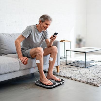 Person using the Welliawell WY-320 EMS foot stimulator during a seated home routine