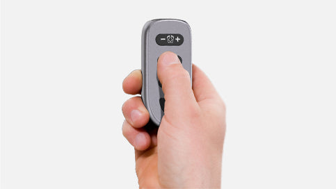 Hand using the remote control for the WY-360 EMS foot stimulator